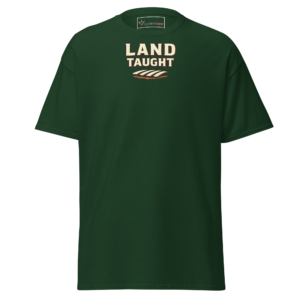 Front view of a forest-green T-Shirt featuring cream “Land Taught” lettering above a small furrowed-field motif