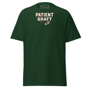 Front view of a forest-green T-Shirt featuring cream “Patient Graft” lettering above a small crossed-tool emblem