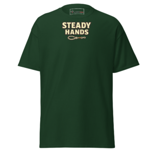 Front view of a forest-green T-Shirt featuring cream “Steady Hands” lettering above a small linked-hand or chain emblem