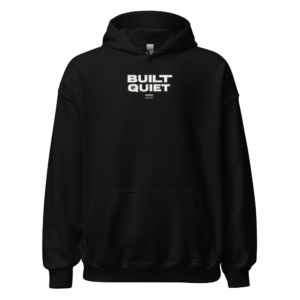 Back view of a black Hoodie featuring bold cream “Built Quiet” lettering with a small curved mark beneath