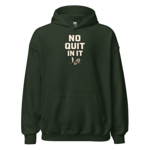 Front view of a forest-green Hoodie featuring cream “No Quit In It” lettering above a small crossed-tool motif